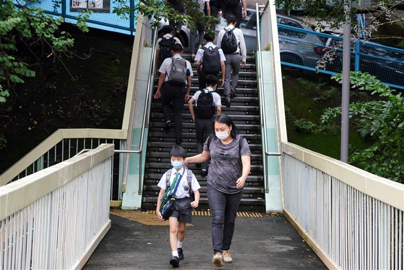鑑於香港武漢肺炎疫情正在惡化,港府20日宣布,本地小學一至三年級學生自23日起暫停面對面授課14天。圖為家長接送孩子上下學。(中新社)