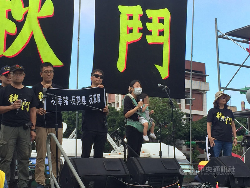 秋鬥遊行22日下午登場,民間反瘦肉精毒豬聯盟成員王靖媛用背帶抱著孩子(右2)表示,她把票投給總統蔡英文,但為了孩子,呼籲政府不需要拿孩子的健康去換取任何的利益。中央社記者楊淑閔攝 109年11月22日