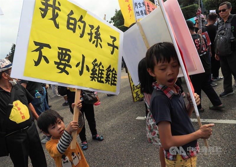 工運指標活動「秋鬥」22日登場,遊行隊伍分為三大隊,表達「反毒豬、反雙標、反黨國」訴求,主辦方下午2時17分宣布遊行正式出發,小朋友手舉看板上街。中央社記者吳家昇攝 109年11月22日