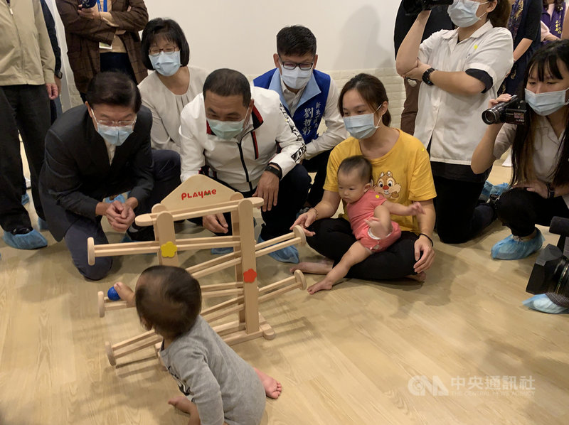 新北市長侯友宜(前中,白外套者)23日到新店區出席新北市第76到80家公共托育中心聯合開幕儀式,與現場小朋友互動。中央社記者沈佩瑤攝 109年11月23日