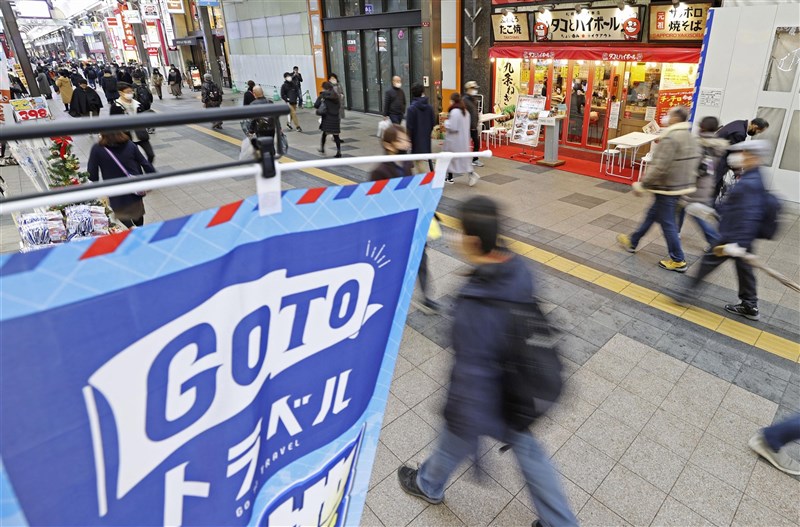 日本首相菅義偉14日宣布,因武漢肺炎疫情擴散,從12月28日到明年1月11日全面暫停實施振興旅遊方案。圖為北海道札幌狸小路商店街上懸掛振興旅遊(Go To Travel)宣傳旗幟。(共同社)