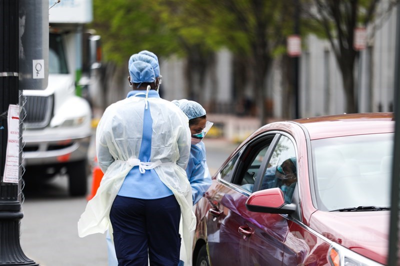 路透社統計官方數據顯示,美國24日染疫住院人數超過8萬7000人,來到歷史新高。圖為4月華盛頓一處「得來速」武漢肺炎檢測站。(中央社檔案照片)