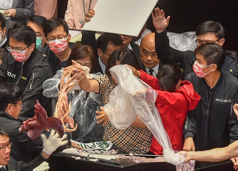行政院長蘇貞昌27日第13度赴立法院施政報告,朝野立委在發言台前爆發衝突,國民黨立委朝台上丟豬內臟,民進黨立委王美惠隨即抓起回丟。中央社記者鄭清元攝 109年11月27日