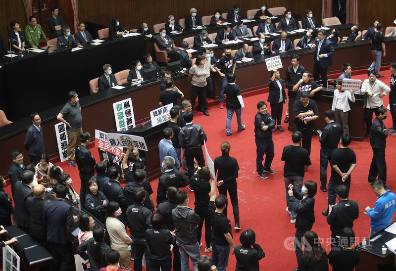 行政院長蘇貞昌27日第13度赴立法院進行施政報告並備質詢,時代力量邱顯智(拿麥克風者)質詢時,受到國民黨立委拿紙板阻擋與哨音干擾,便站到椅子上發言。中央社記者張新偉攝 109年11月27日
