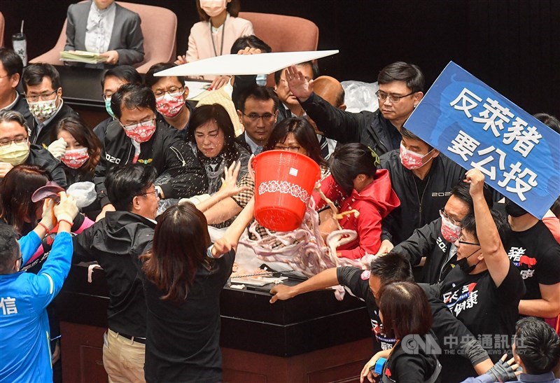 行政院長蘇貞昌27日第13度赴立法院施政報告,朝野立委爆發衝突,國民黨立委朝台上倒豬皮與內臟,民進黨立委則以人牆及紙板遮擋,保護蘇貞昌。中央社記者鄭清元攝 109年11月27日