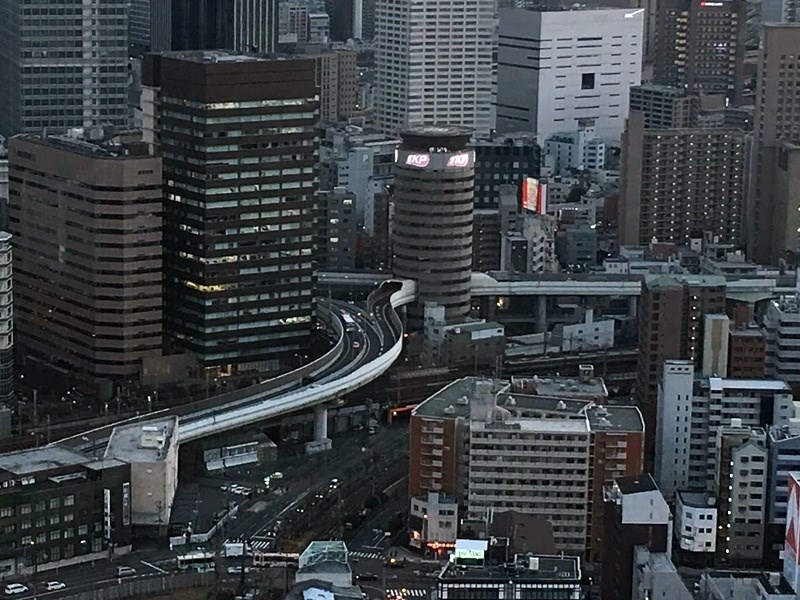 日本大阪阪神高速公路穿越「門塔大廈」（圖中圓形建物），形成街景中的一幅奇特畫面。（讀者提供）