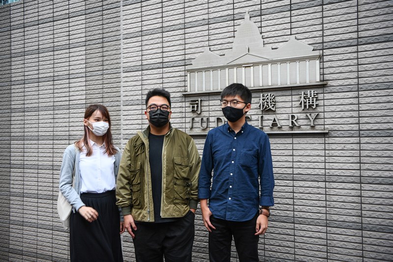 前香港眾志成員黃之鋒(右)、周庭(左)和林朗彥(中)2日被法院判處7至13.5個月不等的有期徒刑。他們從2012年「反國教」運動起,並肩作戰近10年,陪伴彼此的青春,也見證香港社運的興衰。圖為3人11月23日出庭前合照。(中通社提供)中央社 109年12月2日