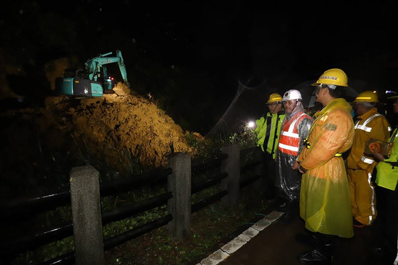 台鐵瑞芳至猴硐間3日才修復的邊坡,4日再度大片滑落,已派員全力搶修中。交通部長林佳龍(前右2)晚間冒著大雨前往坍方現場,視察搶修進度,也肯定台鐵落實標準作業程序,確保乘客安全。(交通部提供)中央社記者黃旭昇新北市傳真 109年12月4日