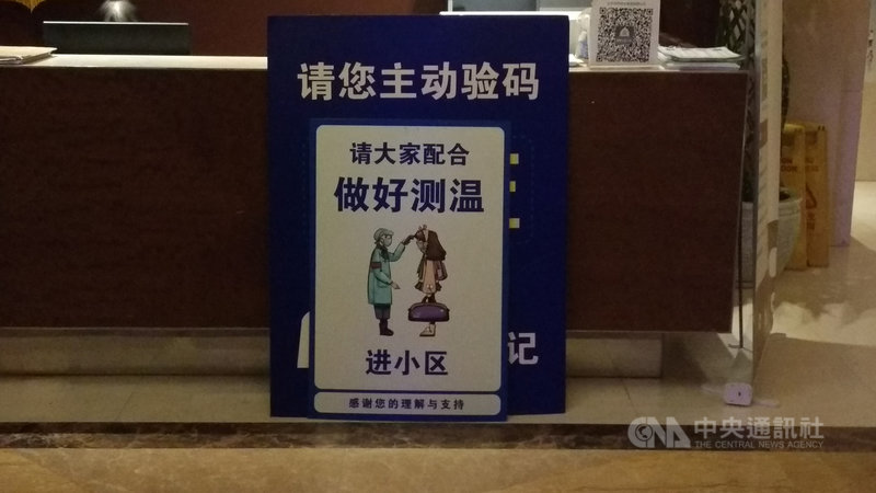 在中國疫情高峰時,各個建築都會擺上這面要求測量體溫的看板。在疫情趨緩後,看板仍在,只是不一定會再執行量體溫。圖為北京一處公寓大廳的告示板。中央社記者邱國強北京攝 109年12月6日