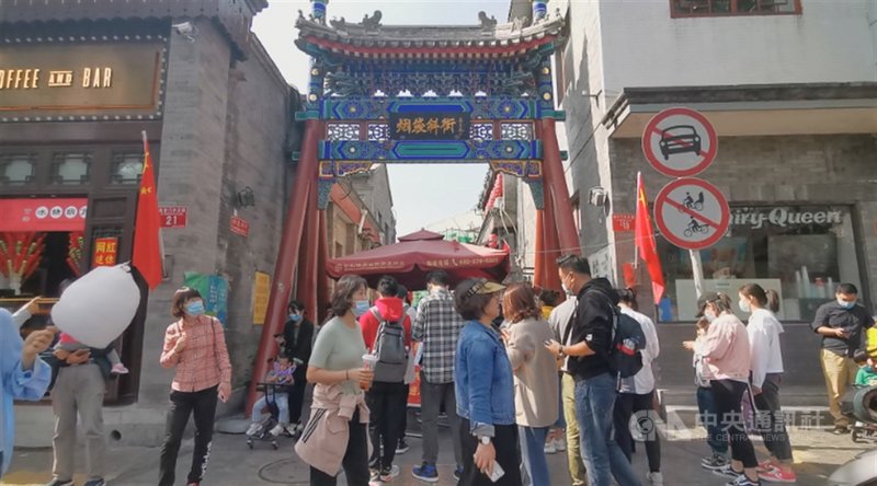 隨著疫情趨緩,中國的街道上已大致恢復昔日的繁榮,人們戴著口罩出門逛街。圖為北京著名景點什剎海旁的煙袋斜街。中央社記者邱國強北京攝 109年12月6日