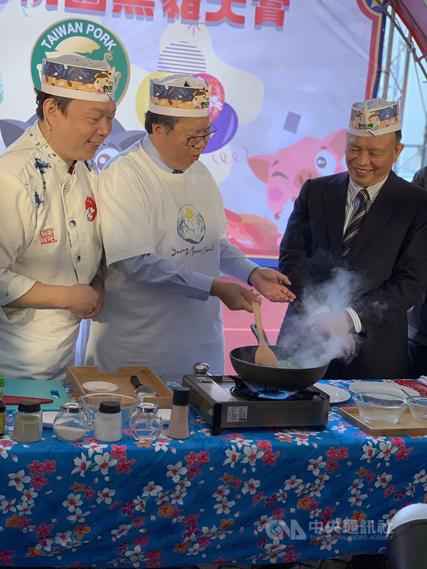 桃園市長鄭文燦（中）與中央畜產會董事長林聰賢（右）9日出席2020桃園黑豬肉大賞記者會，一同下廚炒豬肉，推廣民眾食用國產豬。中央社記者葉臻攝　109年12月9日