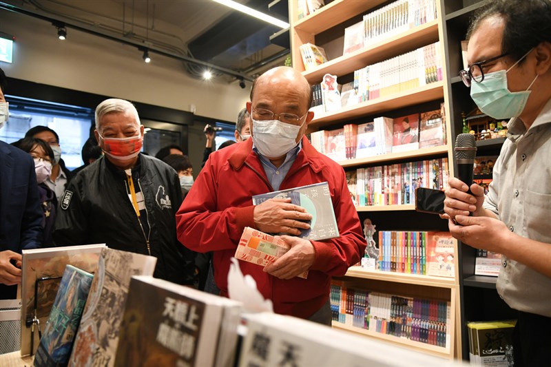 行政院長蘇貞昌(中)13日參訪位在台北市華陰街的「台灣漫畫基地」,以三倍券購買近新台幣3000元的漫畫,支持台灣原創作品。(行政院提供)中央社 109年12月13日