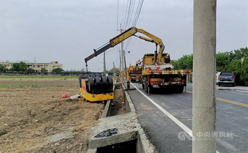 嘉義縣鹿草鄉16日發生意外事故，一名男子開壓路機要上拖板車，疑操作不慎，翻覆路旁農田，人被壓在壓路機下，警消獲報到場搶救，已無生命跡象中央社記者蔡智明攝 109年12月16日