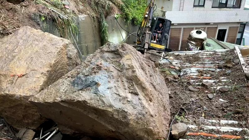 新北市瑞芳區鼻頭路一處岩壁15日下午5時許崩落,2戶民宅受損嚴重,相關單位16日上午出動機具從民宅旁巷弄進入,將掉落在民宅屋頂的數顆大石碎解,以便後續清運。中央社記者王朝鈺攝 109年12月16日
