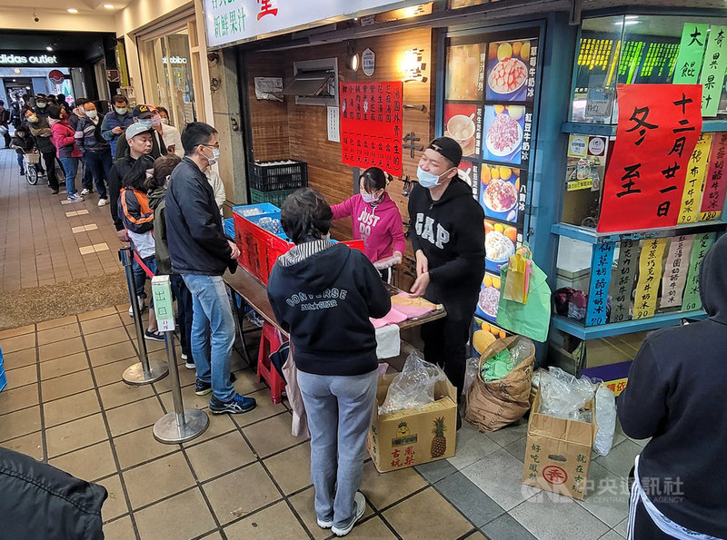 冬至佳節到,北部地區21日不時飄下雨絲,天氣溼冷,有店家在店門外擺起應景湯圓攤位,吸引民眾排隊買湯圓、好過節。中央社記者鄭清元攝 109年12月21日