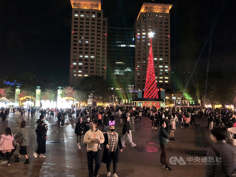 2020新北歡樂耶誕城持續展開，22日晚間仍有不少民眾戴著口罩前往市民廣場欣賞光雕、燈飾光廊。中央社記者黃旭昇新北市攝　109年12月22日