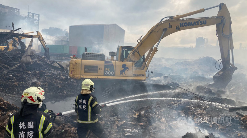 旭富製藥公司20日爆炸起火，鄰近桃園紙廠也受波及，紙廠內的廢紙帶著火苗飛散，消防局22日加派怪手開挖紙團澆水。（消防局提供）中央社記者葉臻傳真 109年12月22日