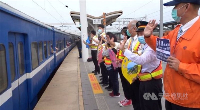 全台僅存的藍皮普快列車23日起停駛,22日最後一班列車吸引許多民眾搭乘。當列車駛出車站,台鐵人員在月台列隊,向藍皮火車揮手道別。中央社記者郭芷瑄攝 109年12月22日