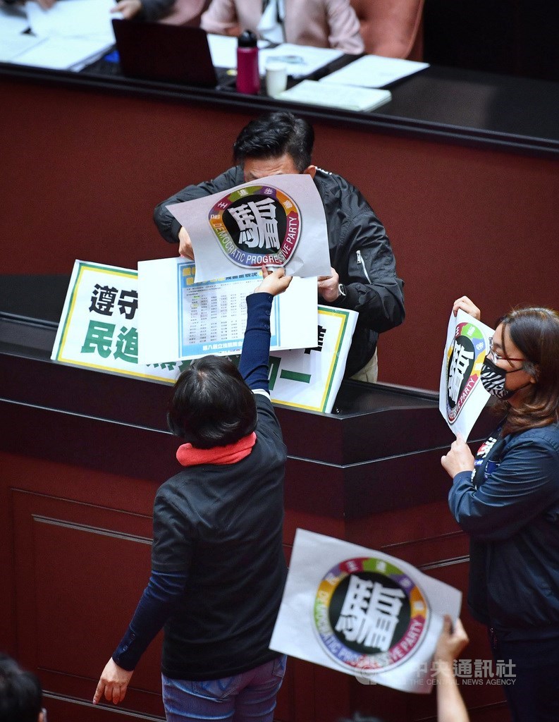 立法院會24日處理食管法部分條文修正草案,在野黨提案多項條文修正案,包含食品、食品添加物應在外包裝標示萊劑、新增萊劑貨號,並羅列不得檢出萊劑的場所;但因民進黨團具人數優勢,在野黨版本並未通過。圖為國民黨立委楊瓊瓔(前中)在民進黨立委郭國文合併發言時,高舉湊近「騙」字抗議海報。中央社記者王飛華攝 109日12月24日