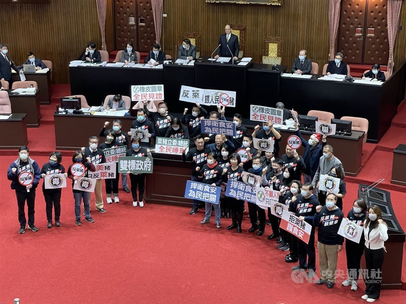 立法院會24日上演萊豬表決大戰,但有民進黨立委跑票,民進黨立法院黨團周春米說,會列為30日黨團會議的報告事項,由黨團會議決定。圖為國民黨立委在議場高喊「全民拒吃瘦肉精,萊豬直送民進黨」等口號。(中央社檔案照片)