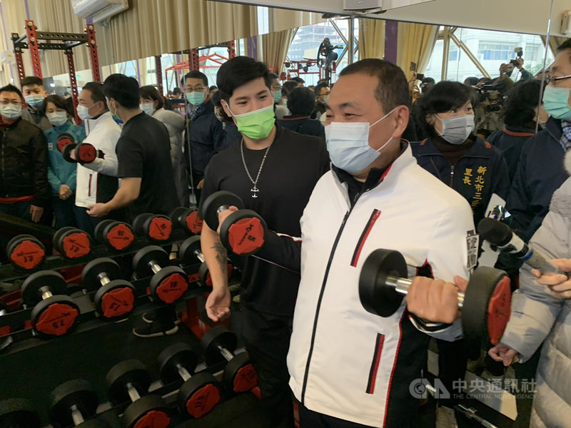 新北運動中心2.0計畫盤點公有空間進行活化,31日於三重區中興市民活動中心啟用第6處「運動聚點」,市長侯友宜(前右)視察環境,並與教練一同體驗啞鈴、壺鈴及敏捷訓練。中央社記者沈佩瑤攝 109年12月31日