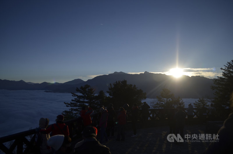 為迎接阿里山公元2021年第一道曙光,許多遊客不畏寒流上山,上午7時許第一道曙光從山脈間躍出,光芒四射,映在無邊雲海上,遊客紛紛拿起手機與相機捕捉美麗瞬間。中央社記者蔡智明攝 110年1月1日