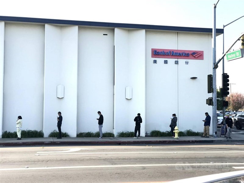 世衛專家警告,在疫苗扭轉2019冠狀病毒疾病疫情前,今年可能會有6個月「最艱辛的道路」要走。圖為6日洛杉磯一處銀行外民眾排隊,保持社交距離。(中央社檔案照片)