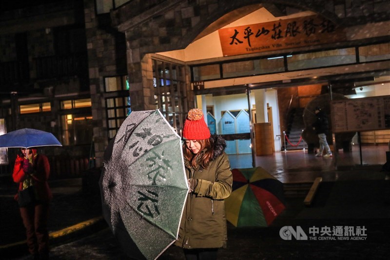 林務局羅東林區管理處表示,寒流來襲,海拔約1900公尺高的太平山國家森林遊樂區7日晚上開始下雪,太平山莊遊客的雨傘積雪,遊客在上頭寫上只想旅行4字。中央社記者吳家昇攝 110年1月7日