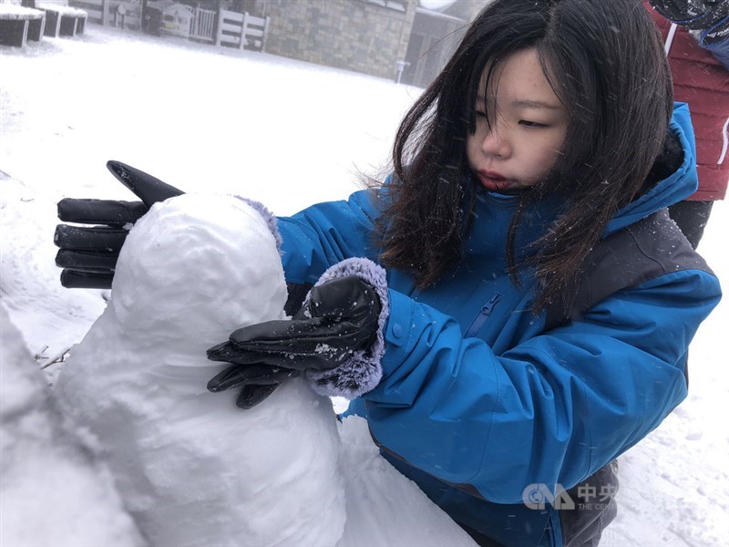 寒流來襲,太平山國家森林遊樂區8日一早已積雪3公分,民眾穿著禦寒衣物、戴著手套堆雪人。中央社記者王騰毅攝 110年1月8日