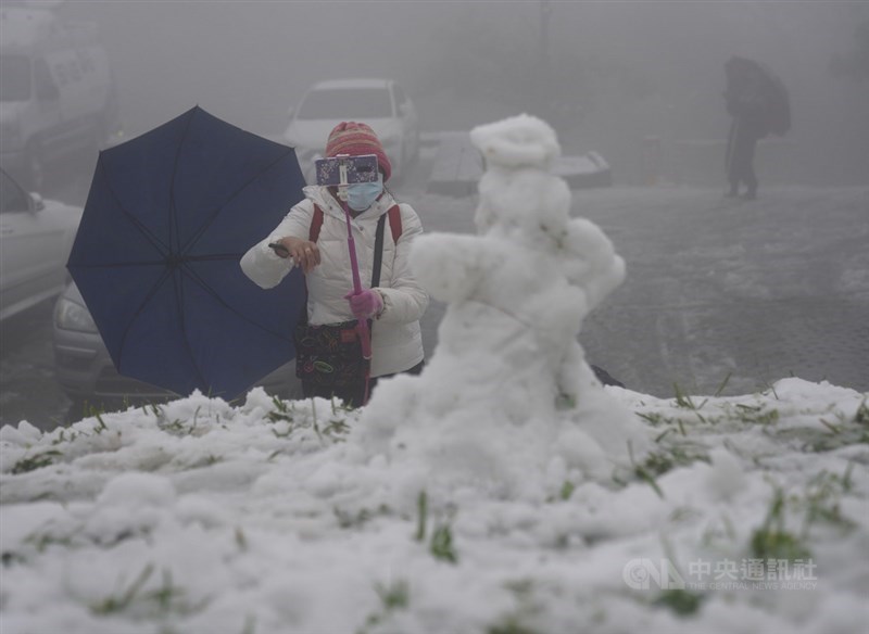 寒流發威,各地高山降雪。不少民眾8日一早上陽明山二子坪追雪,做雪人。中央社記者徐肇昌攝 110年1月8日