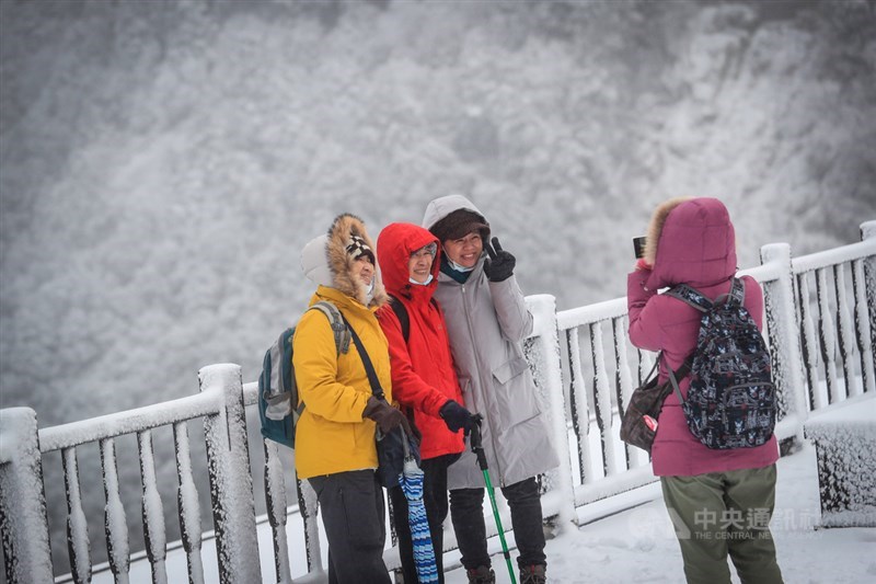 寒流來襲,海拔約1900公尺高的太平山國家森林遊樂區7日晚間降雪,8日清晨積雪變厚,遊客合照留念。中央社記者吳家昇攝 110年1月8日