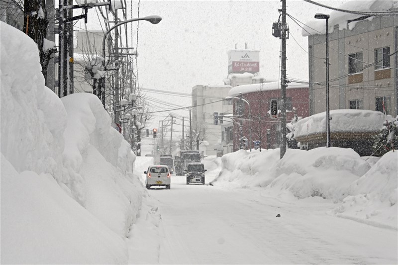 日本東北及北陸地區受到「炸彈低氣壓」影響,下起大雪且颳暴風。強風已造成秋田縣的電線斷線,將近4萬戶停電。圖為秋田縣降雪情況。(共同社)