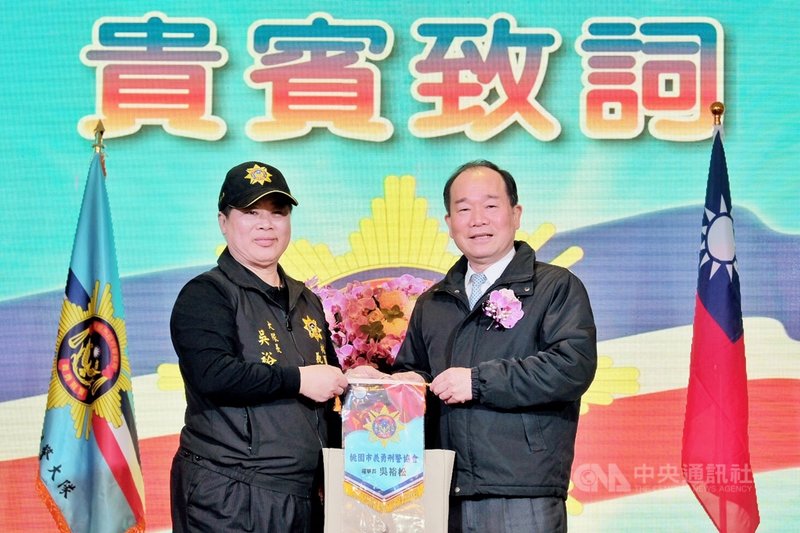 由桃園市企業界人士成立的桃園市義勇刑警協會10日正式成軍,桃園市警察局長陳國進(右)授旗給義勇刑警協會首屆理事長並擔任大隊長的吳裕松(左)。中央社記者吳睿騏桃園攝 110年1月10日