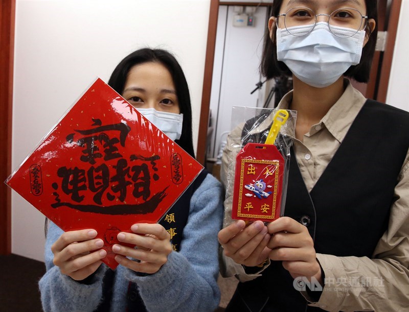 新版護照發行首日,外交部領事事務局11日備妥限量禮品「行李平安吊牌」及「招財進寶/追求自由民主創意春聯」,歡迎民眾踴躍換發護照。中央社記者郭日曉攝 110年1月11日
