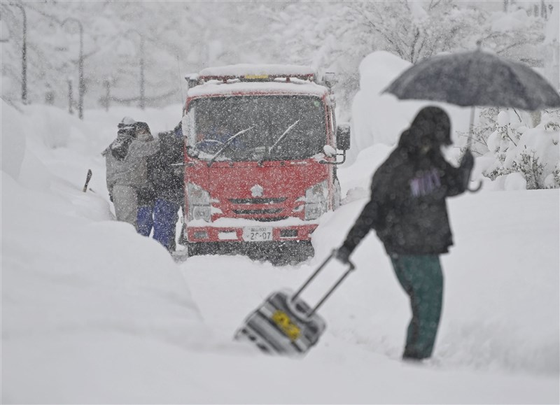日本新潟、北陸等地從7日起連續下大雪,這場雪災造成至少11人死亡,超過330多人輕重傷。圖為9日富山市消防車困在雪中。(共同社)