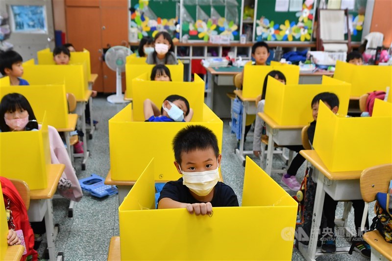 為了防疫,台灣各級學校延長寒假。開學之初,台北市大佳國小學童除了戴口罩上課,還在教室內使用自製的隔板,降低飛沫傳染的機率。中央社記者林俊耀攝 109年2月26日