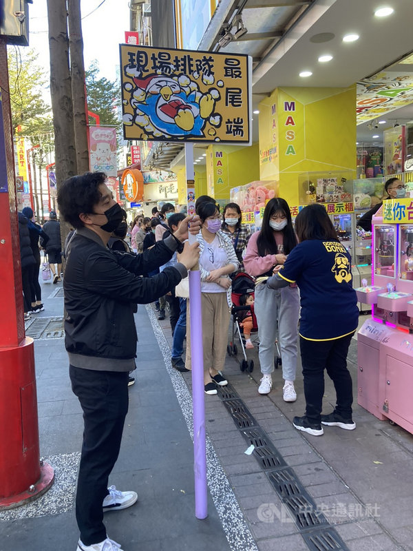 日本知名零售連鎖店唐吉訶德登台,吸引大批排隊人潮,北市府21日要求加強防疫措施,目前業者已改採發放「快速通關手環」,並限制時段與人數入場。中央社記者陳昱婷攝 110年1月21日