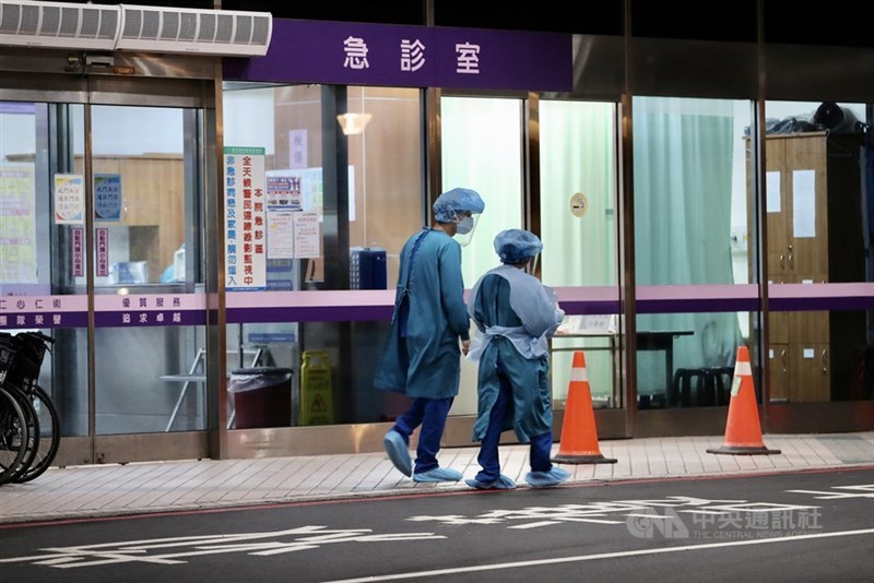 疫情指揮中心24日宣布,台灣增2例本土個案,為桃園醫院群聚衍生,為出院病患及其同住家人。圖為桃醫周邊身著防護衣的工作人員走動。(中央社檔案照片)