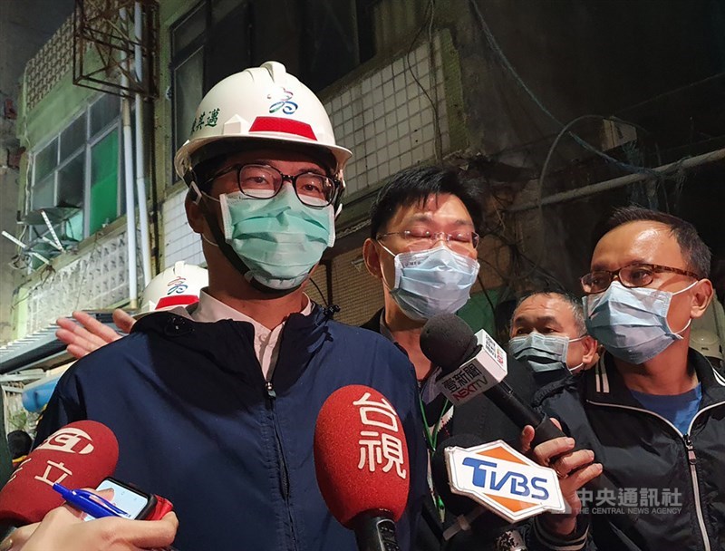 高雄市新興區舊今日戲院大樓外牆28日下午突然倒塌,未釀人員傷亡。高雄市長陳其邁(左)到場了解搜救處理情形後表示,目前無跡象顯示有人受困瓦礫堆,晚間會請消防局和工務局進駐將路面坍塌部分清除,牆面上的帷幕29日也會清掉。中央社記者洪學廣攝 110年1月28日
