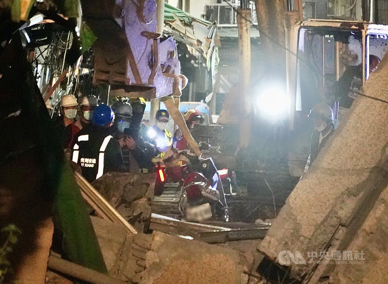 高雄市新興區舊今日戲院建築外牆28日下午突發坍塌意外,所幸未釀人員傷亡,消防局和工務局晚間出動人力、機具,協助先將路面坍塌部分清除,並將遭波及機車等吊離現場。中央社記者董俊志攝 110年1月28日
