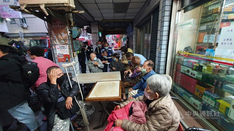 高雄市新興區八德二路一棟5層廢棄戲院28日下午發生外牆倒塌意外,波及對面4戶住家,多名長者受到驚嚇,被緊急安置在附近騎樓下。中央社記者洪學廣攝 110年1月28日