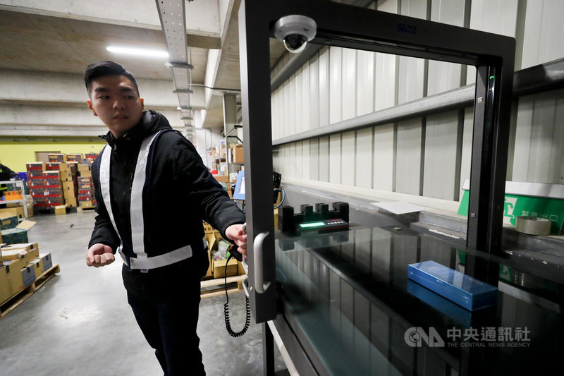 永聯物流電商倉儲導入自動化設備,為客戶提供客製化物流和倉儲服務,從量測體積、撿貨運送到出貨都有標準作業程序(SOP)。圖為負責進口酒品專倉和電商專倉的馬文賢操作自動材積量測儀。中央社記者裴禛攝 110年1月31日