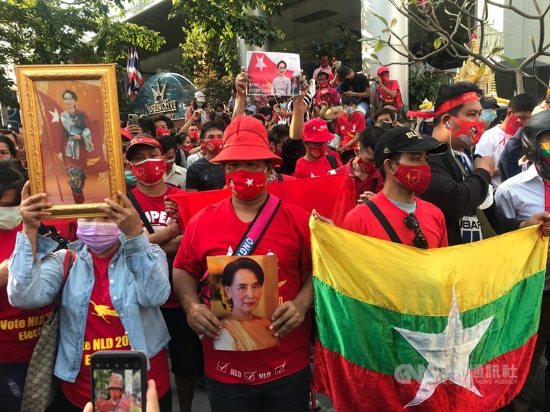 緬甸軍方發動政變,多名在泰國的緬甸人1日下午身穿代表全民盟的紅色衣服並高舉翁山蘇姬的照片,聚集在緬甸駐泰國大使館前,抗議緬甸軍方的作為。中央社記者呂欣憓曼谷攝 110年2月1日