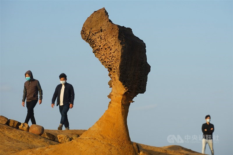 交通部觀光局3日公布春節旅遊人流管制措施,將針對所轄13個國家風景區及25家觀光遊樂業實施總量管制、預警分流遊客及防疫措施。圖為民眾帶著口罩走訪北海岸風景區野柳地質公園著名地標「女王頭」。中央社記者王騰毅攝 110年2月3日