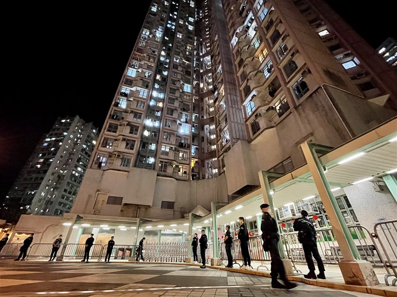 香港有一名傳播源頭不明的本土確診病患因失聯遭到警方通緝。圖為3日晚間警方派員駐守柴灣一處社區,因居民須禁足強制採檢。(中新社)
