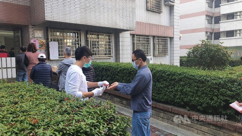 無黨籍高雄市議員黃捷罷免投票6日舉行,罷捷團體發言人徐尚賢(右)上午抵達鳳山建國新城,排隊進行手部酒精消毒,準備進入投票所投票。中央社記者洪學廣攝 110年2月6日