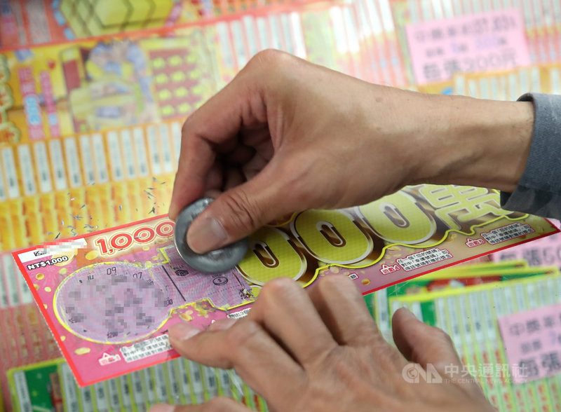 台灣彩券公司衝春節買氣,今年共推出16款新春限定刮刮樂,獎金新台幣百萬以上獎項多達737個,史上最多,近日全台已陸續傳出刮出百萬獎的好消息。圖為民眾買刮刮樂試手氣。中央社記者張新偉攝 110年2月7日