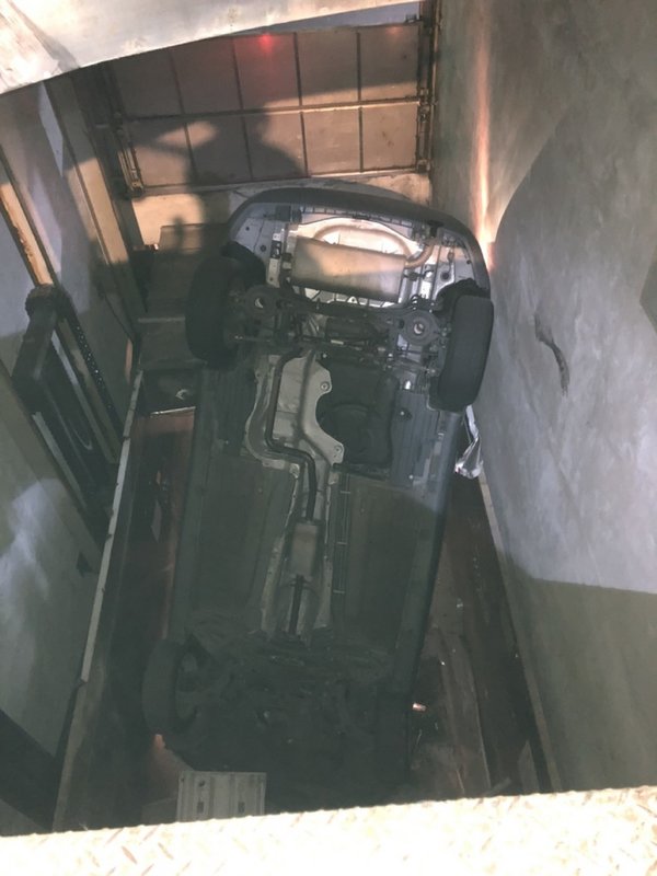 新北市中和區復興路一處社區的機械式停車場7日晚間發生汽車疑似暴衝意外,車輛翻落6公尺深的停車升降機間,警消獲報迅速到場救人。(翻攝照片)中央社記者王鴻國傳真 110年2月7日