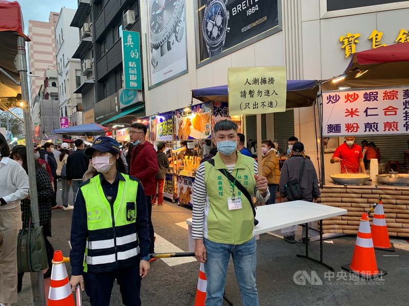 高雄市新樂街市集12日爆量逛街民眾,高市府衛生局緊急派員舉牌「只出不進」管制。中央社記者王淑芬攝 110年2月12日