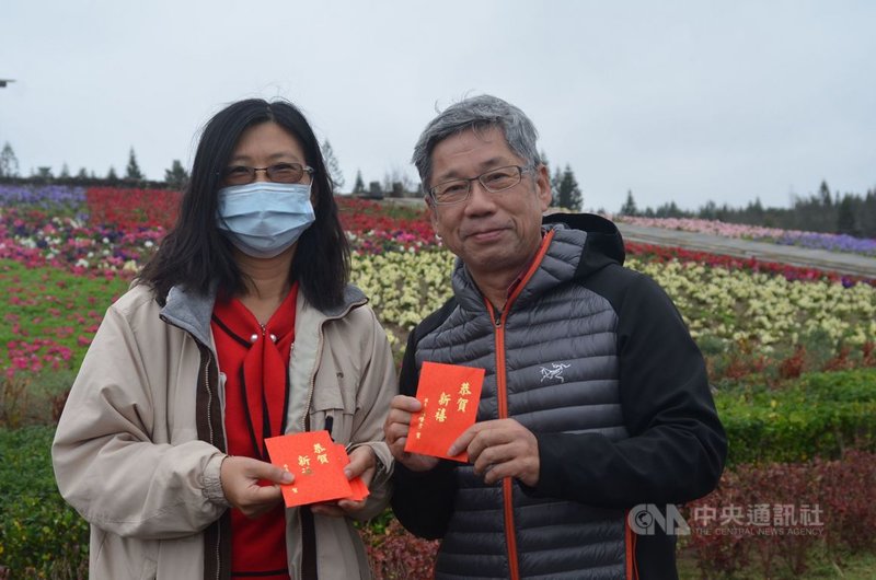 台電澎湖尖山電廠長歐致誠(右)帶著全家前往菜園休憩園區走春賞花,尤其在飄著細雨的天候下,格外的舒適,還領到縣府所致贈的福袋。中央社 110年2月12日